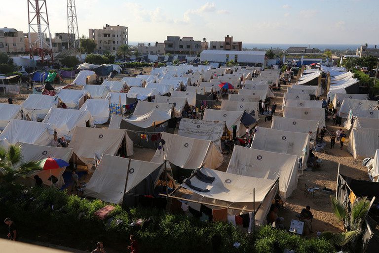 Several rows of identical white tents with the same logo.