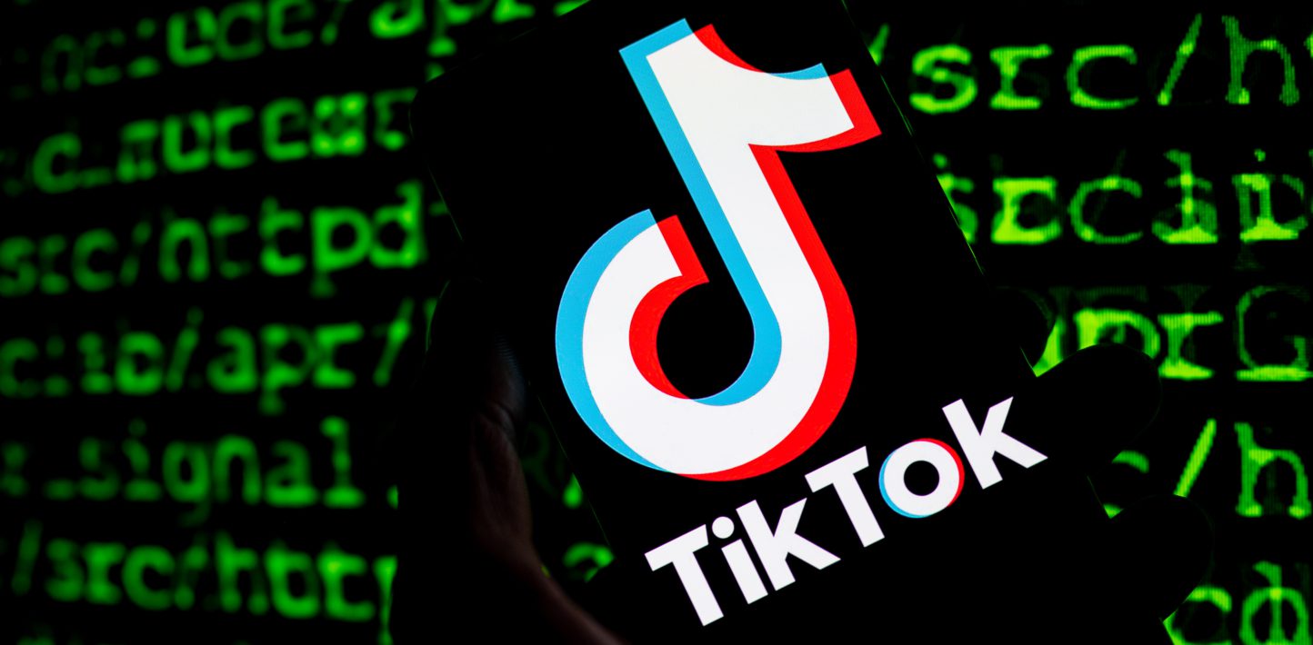 A Tiktok logo is visible in the foreground. In the background, what appears to be green coding text.